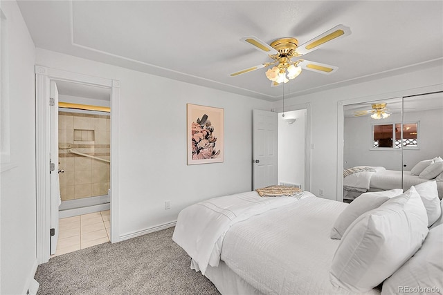 carpeted bedroom featuring a closet, ensuite bathroom, baseboards, and ceiling fan