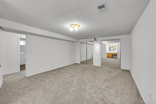 unfurnished bedroom with carpet, a textured ceiling, visible vents, and baseboards