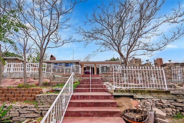 rear view of property with stairs