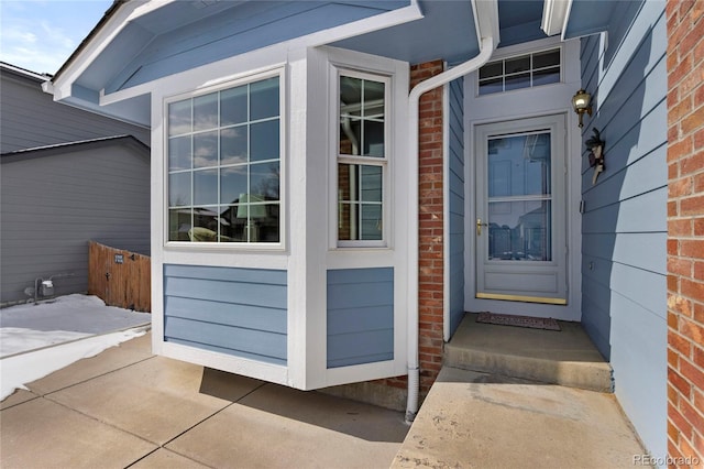 view of exterior entry featuring brick siding