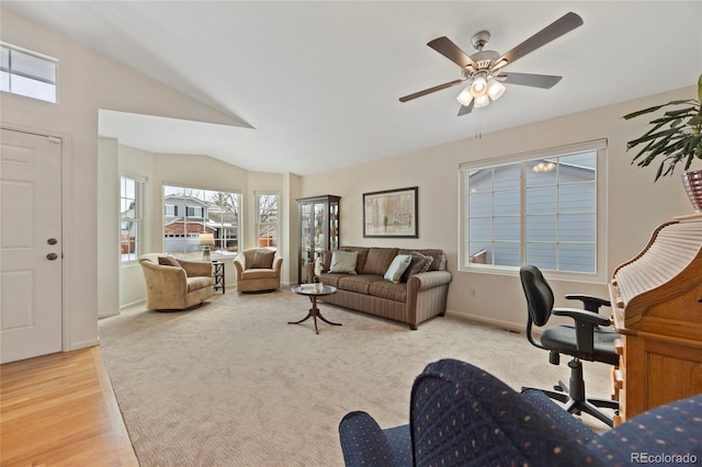 living room featuring lofted ceiling, light wood finished floors, baseboards, and a ceiling fan