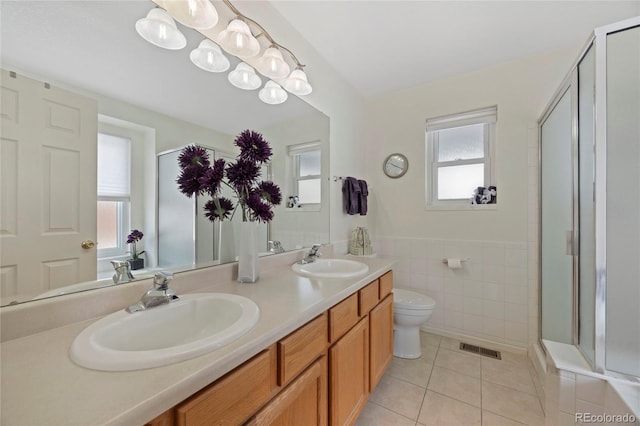 full bath with visible vents, a sink, a shower stall, and tile patterned floors