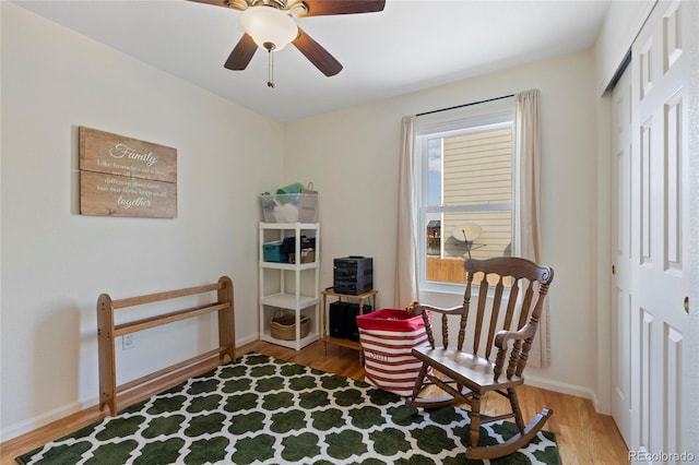 sitting room featuring ceiling fan, wood finished floors, and baseboards