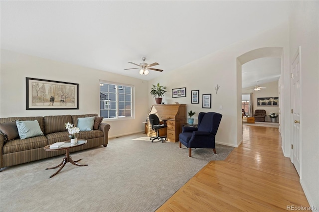 living room with vaulted ceiling, plenty of natural light, arched walkways, and light wood-style floors