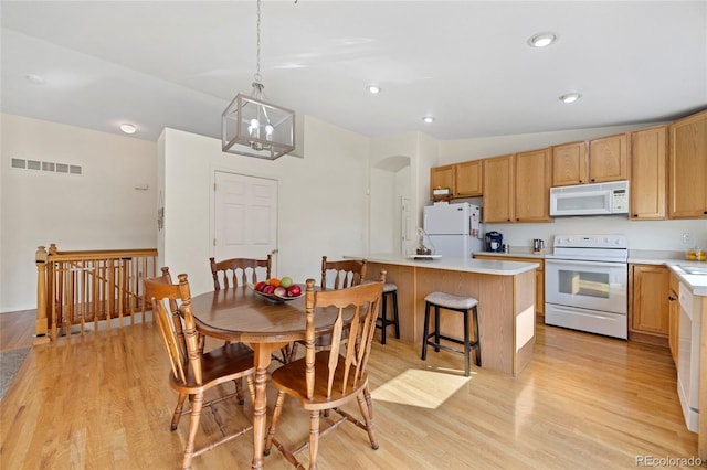 dining space with arched walkways, recessed lighting, visible vents, and light wood-style floors