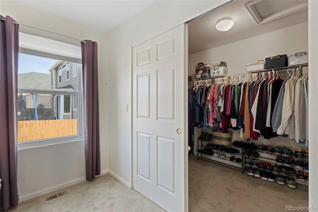 walk in closet featuring light carpet, attic access, and visible vents