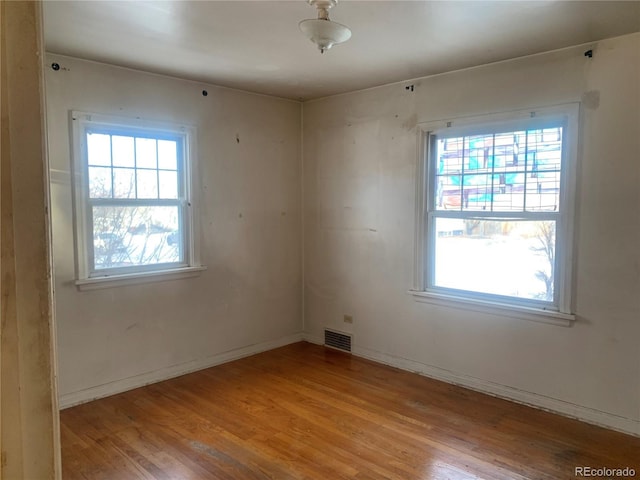 spare room featuring a healthy amount of sunlight and light wood-type flooring