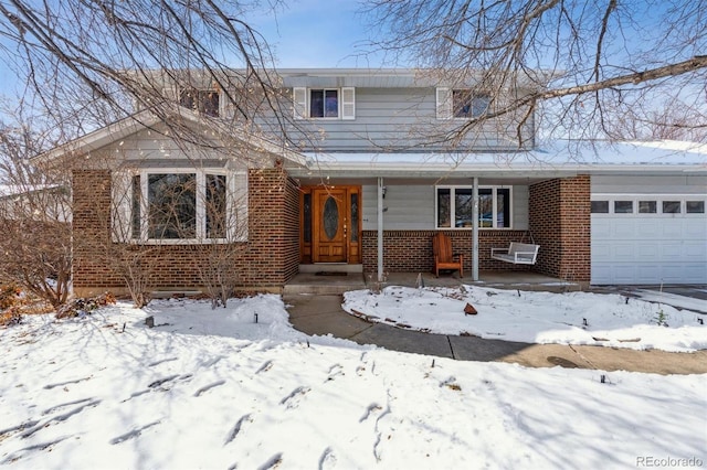 traditional-style house with a porch, brick siding, and a garage