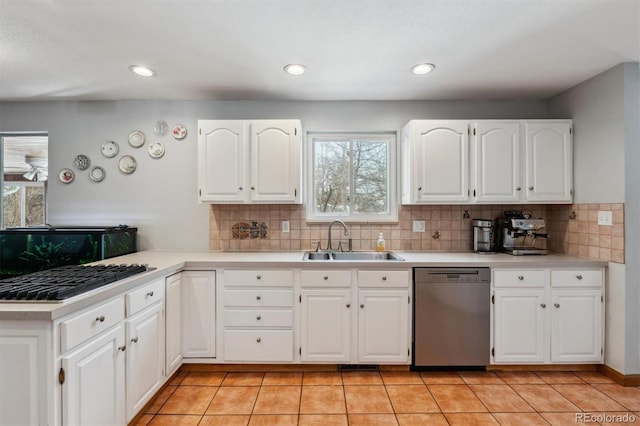 kitchen with light countertops, appliances with stainless steel finishes, a sink, and white cabinets