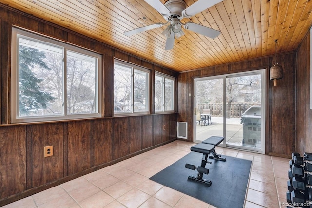 workout area featuring wood ceiling, wood walls, and a wealth of natural light