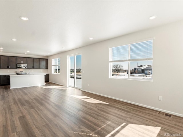 unfurnished living room with baseboards, visible vents, wood finished floors, and recessed lighting