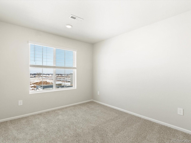 carpeted empty room featuring visible vents and baseboards