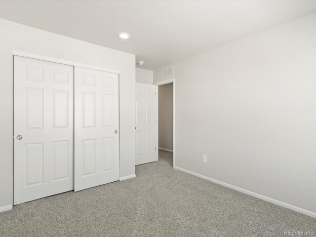 unfurnished bedroom featuring baseboards, visible vents, carpet floors, a closet, and recessed lighting