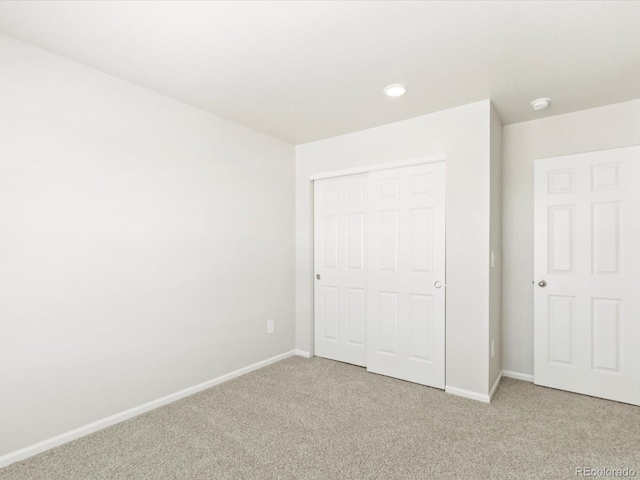 unfurnished bedroom with carpet, baseboards, and a closet