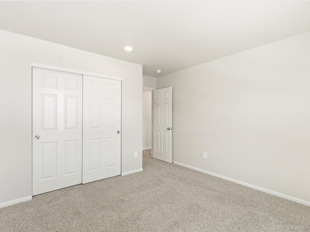 unfurnished bedroom featuring carpet, a closet, and baseboards