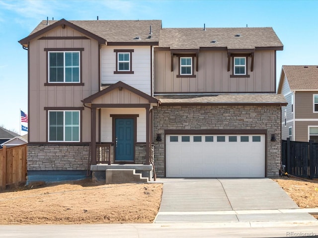 view of front facade featuring board and batten siding, driveway, a garage, and fence