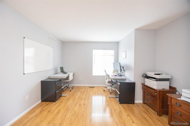office area featuring light wood-style floors, visible vents, and baseboards