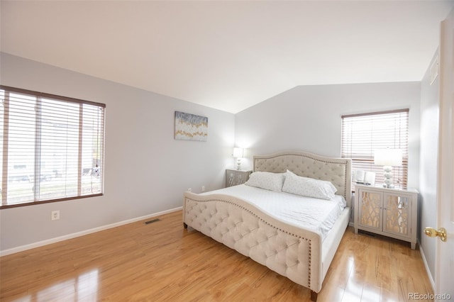bedroom featuring lofted ceiling, visible vents, light wood-style floors, and multiple windows