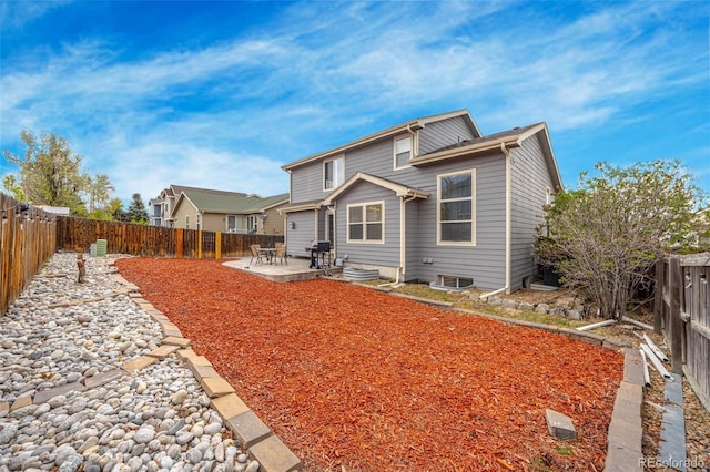 rear view of house with a fenced backyard and a patio