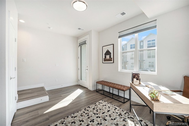 office area with wood finished floors, visible vents, and baseboards