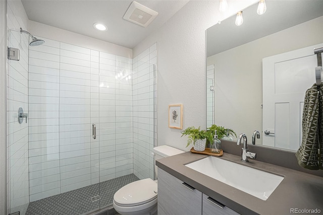 bathroom with a stall shower, visible vents, toilet, vanity, and recessed lighting