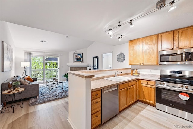 8200 E 8th Ave Unit 5-204, Denver, CO 80230 - kitchen with appliances with stainless steel finishes, a sink, open floor plan, a peninsula, and light wood-style floors