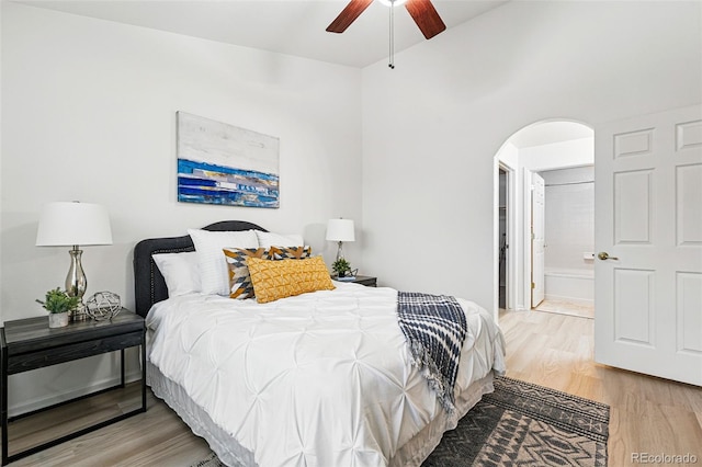 8200 E 8th Ave Unit 5-204, Denver, CO 80230 - bedroom featuring arched walkways, light wood-style flooring, ensuite bathroom, and a ceiling fan