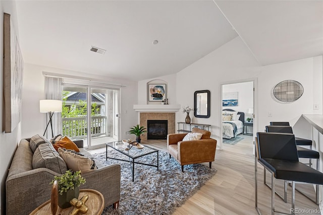 8200 E 8th Ave Unit 5-204, Denver, CO 80230 - living room with vaulted ceiling, light wood-style flooring, and a tile fireplace