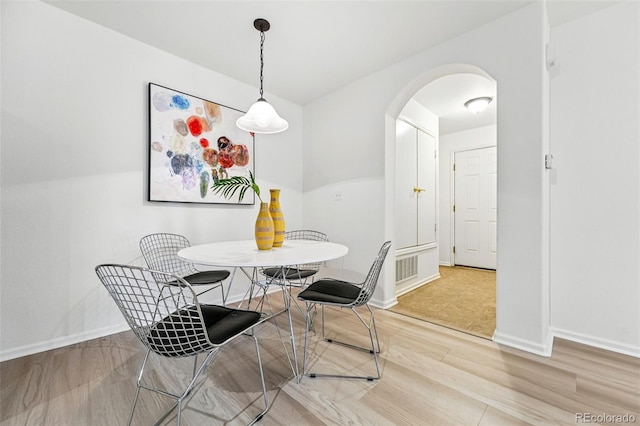 8200 E 8th Ave Unit 5-204, Denver, CO 80230 - dining room featuring arched walkways, light wood finished floors, and baseboards