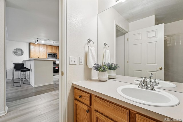8200 E 8th Ave Unit 5-204, Denver, CO 80230 - bathroom with rail lighting, wood finished floors, vanity, and baseboards