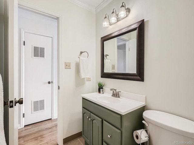 2301 E Fremont Ave Unit W03, Centennial, CO 80122 - bathroom with ornamental molding, vanity, toilet, wood finished floors, and baseboards