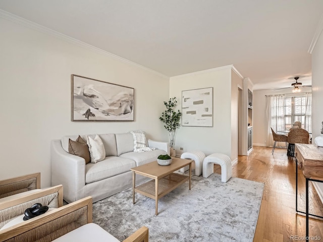 2301 E Fremont Ave Unit W03, Centennial, CO 80122 - living area with crown molding, light wood finished floors, a ceiling fan, and baseboards