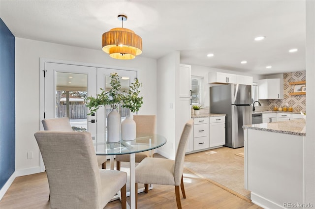 dining area with sink and light hardwood / wood-style floors