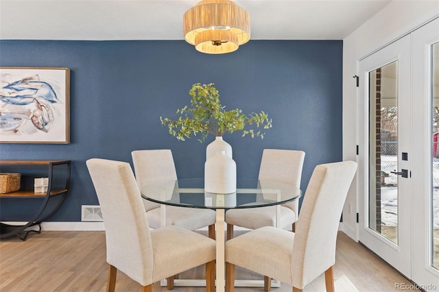 dining room featuring french doors and light wood-type flooring