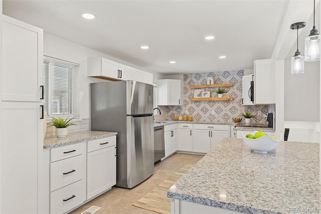 kitchen with light tile patterned flooring, pendant lighting, tasteful backsplash, white cabinets, and stainless steel appliances