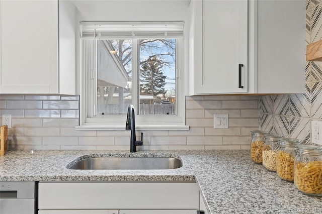 kitchen featuring white cabinetry, sink, and backsplash