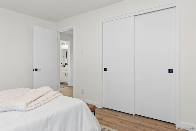 bedroom with sink, a closet, and light wood-type flooring