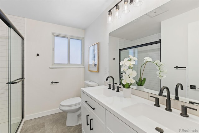 bathroom with vanity, a shower with shower door, and toilet