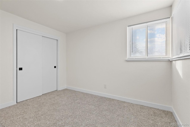 unfurnished bedroom featuring carpet flooring and a closet