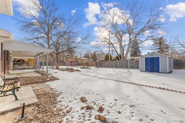 yard covered in snow featuring a shed