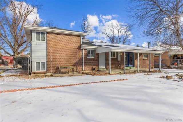 snow covered rear of property with a porch