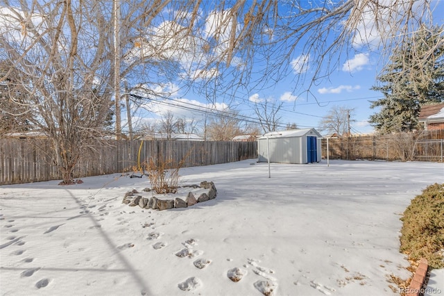 yard covered in snow featuring a shed