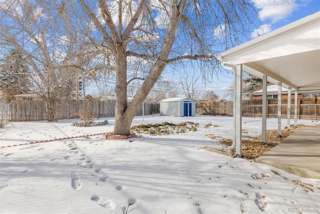 yard layered in snow with a storage shed