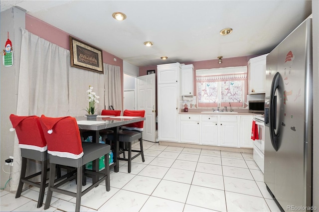 kitchen featuring white cabinets, sink, a kitchen bar, and stainless steel appliances