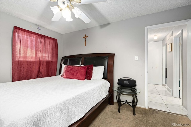 carpeted bedroom with a textured ceiling and ceiling fan