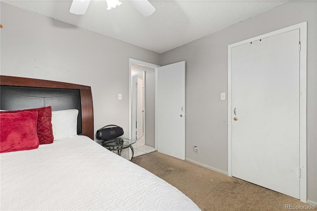 bedroom with light carpet, a textured ceiling, and ceiling fan