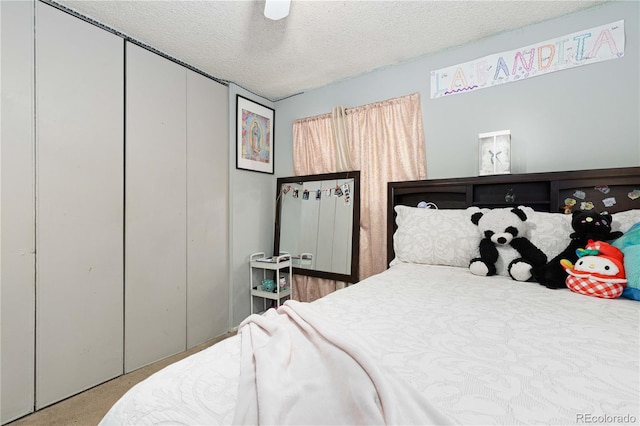 bedroom with carpet flooring, ceiling fan, a textured ceiling, and a closet