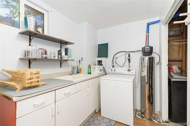 laundry area featuring cabinets, washer / dryer, sink, and light hardwood / wood-style flooring