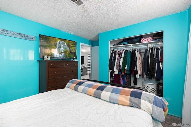 carpeted bedroom with a textured ceiling and a closet