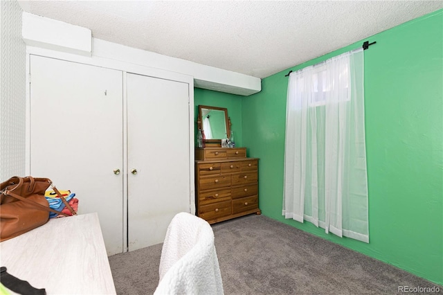 bedroom with carpet, a textured ceiling, and a closet